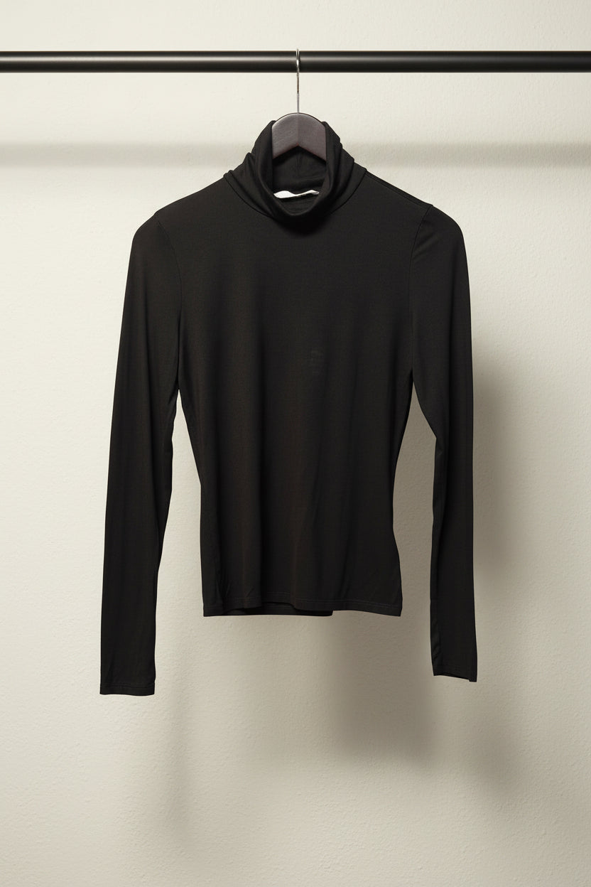 A black long-sleeve mock neck turtleneck sweater hanging on a white hanger against a neutral gray fabric backdrop.
