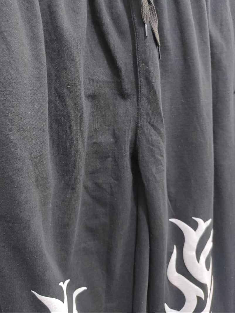 Close-up of dark gray sweatpants with a white graphic print near the lower leg and a gray drawstring at the elastic waistband.