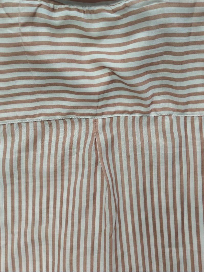A close-up of a striped garment, likely a shirt or pajama top, featuring horizontal stripes in a dusty rose-brown and off-white across the upper portion, and vertical stripes of the same colors on the lower portion.