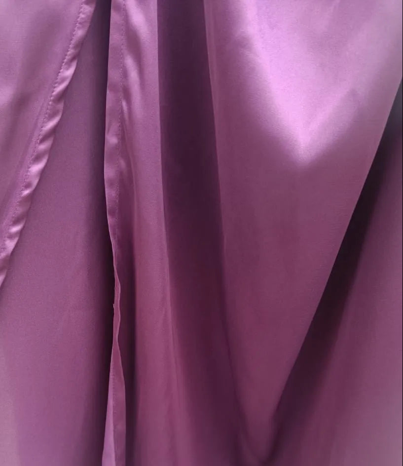 A close-up of draped purple fabric, likely a satin or silky garment, showing the sheen and folds.