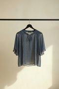 A loose, wide-sleeved blue top with a white chevron pattern, laid flat on a white background.