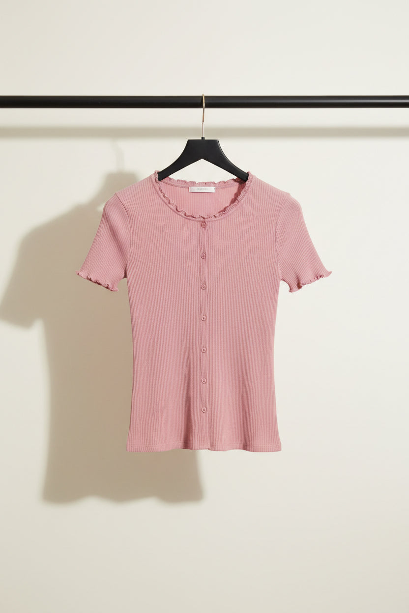A pink short-sleeve ribbed knit cardigan top with a button-up front, laid flat on a light gray fabric background.
