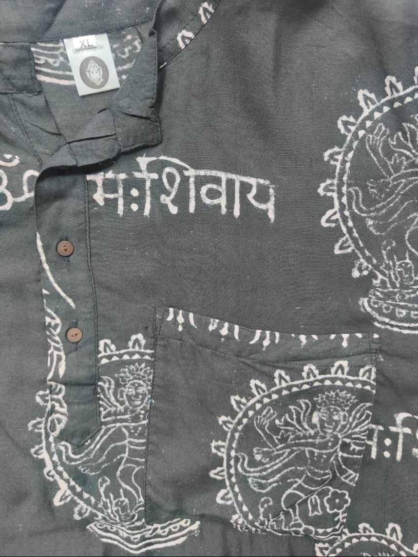 A dark gray linen shirt with white block-printed patterns, including the Devanagari word 'Marsayat' and Laddu designs, featuring a button-down front and chest pocket.